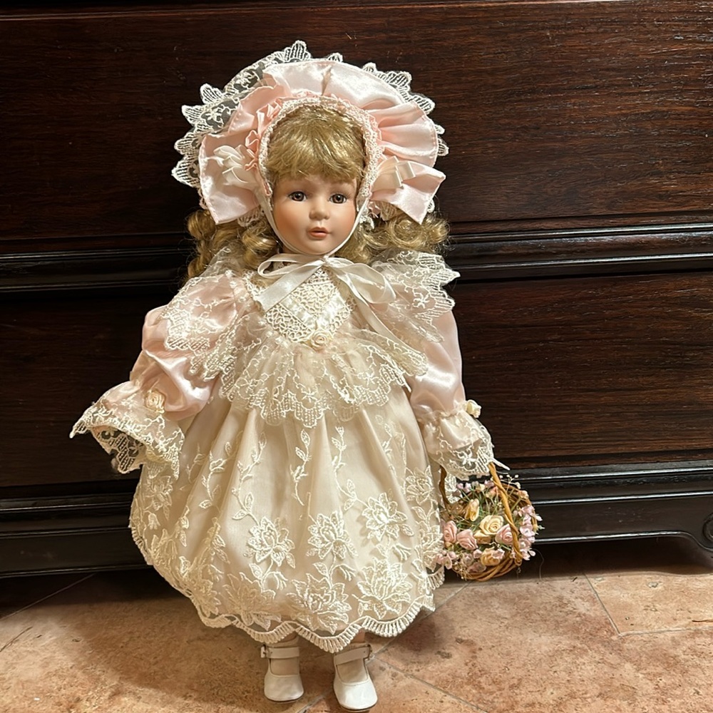 Porcelain doll a vision of soft pale pink with soft golden bouncy curls